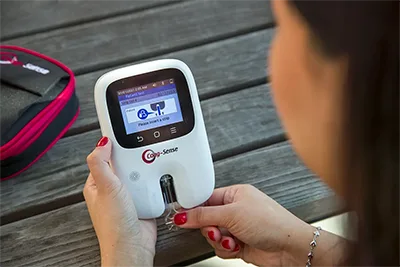 Women holding a Coag-sense machine